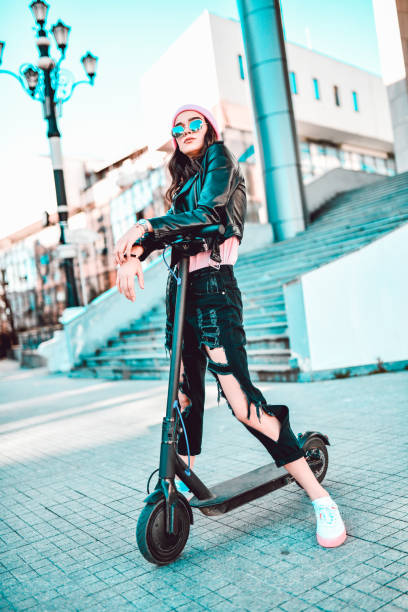 istock Modern Female With Ripped Jeans Riding Electric Scooter 1277751743