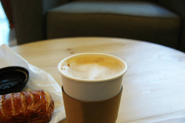 istock cappuccino in paper cup. cappuccino and cake on the table 1277752349