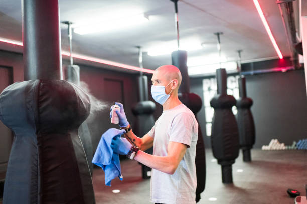 istock Side view man wearing face mask sanitising  gym equipment 1277753716
