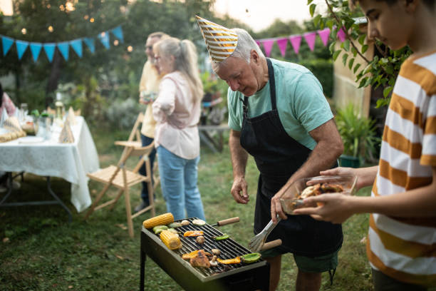 istock Grandfather teaching his grandson how to make barbeque at backyard 1277753990