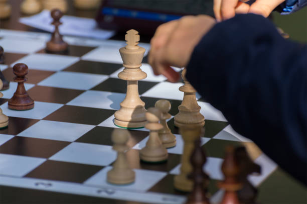 istock Children's hand making move while tournament. Chess Pieces on the Chessboard. 1277761138