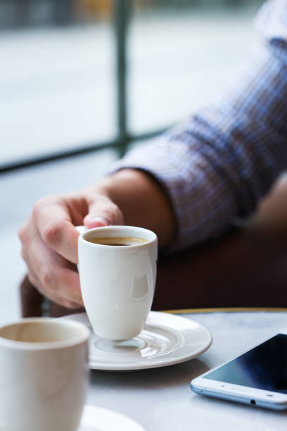 istock Businessman sitting in cafe, drinking morning coffee and using smartphone 1277761729