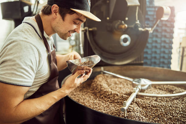 istock Cheerful male worker holding scoop with coffee beans 1277763254