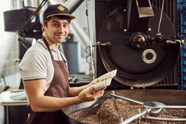 istock Joyful male worker holding two bowls with coffee beans 1277763279