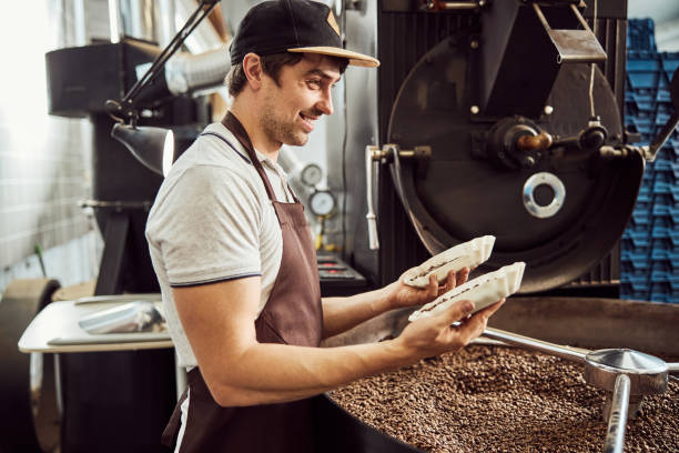 istock Cheerful male worker holding two bowls with coffee beans 1277763312