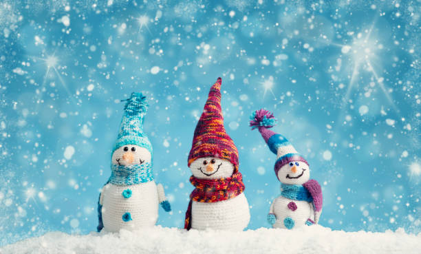 istock Little snowmen on soft snow on blue background 1277763767