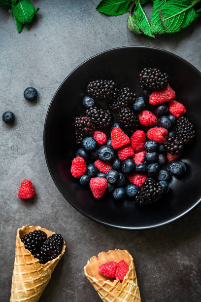 istock Organic berries served in a black plate on dark metal background 1277764543