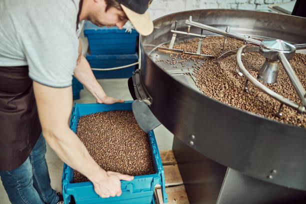 istock Male worker holding plastic crate with freshly roasted coffee beans 1277765733