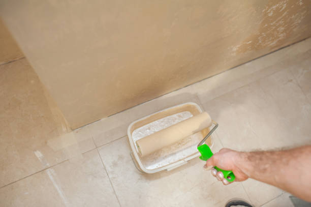 istock A man's hand with a paint roller is painting a wall with decorative plaster in beige. The concept of renovation of apartments and premises. 1277765895