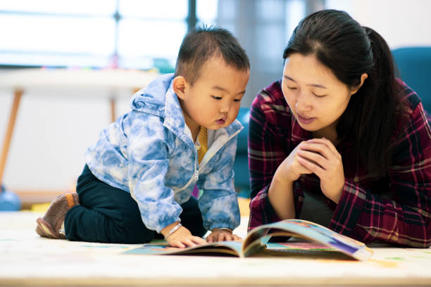 istock Mother reading book with son at home 1277766017