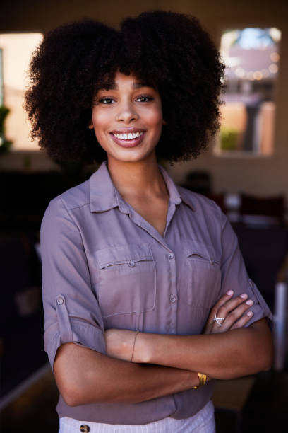 istock Young female entrepreneur smiling while standing in her cafe 1277768611