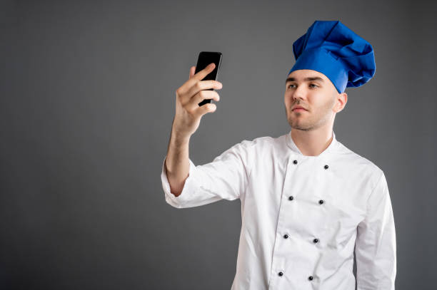 istock Young male dressed in a white chef suit taking selfie photography 1277770139