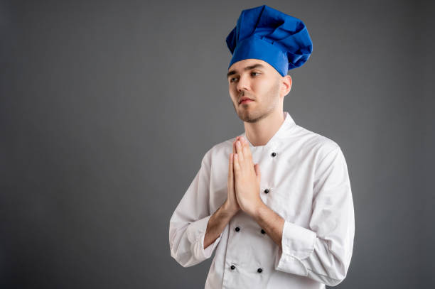 istock Young male dressed in a white chef suit praying 1277770418