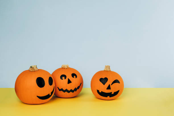 istock Little orange pumpkins with painted faces for Halloween 1277771522