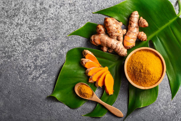 istock Turmeric powder and fresh turmeric root on grey concrete background with copyspace. 1277772633