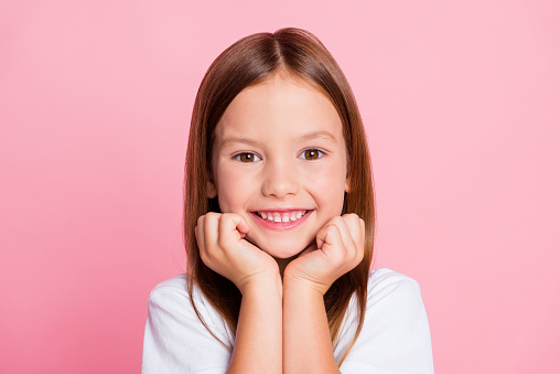 Close-up portrait of a curious ecstatic cheerful cheery girl imagination fantasizing copy empty blank space isolated over pink pastel color background