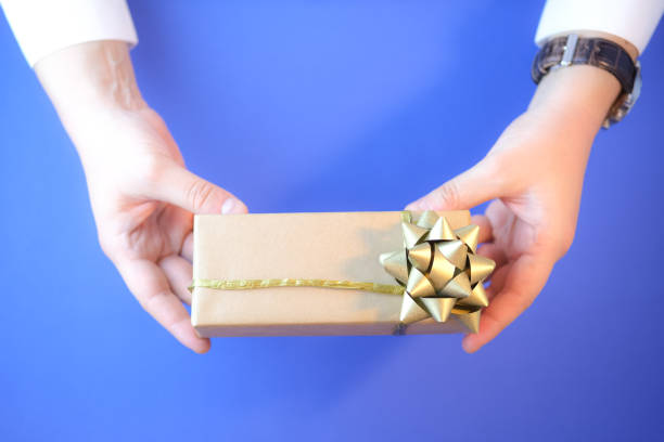 istock Man holding a gift box wrapped in craft paper. 1277775386