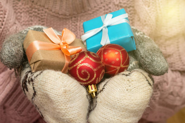 istock hands in a knitted sweater mittens holding gift present box. Christmas holidays preparation concept. 1277775599