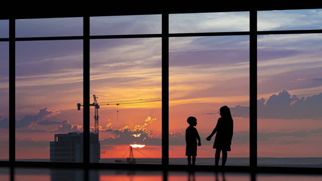 The two kids stand near the big windows on the building background. time lapse
