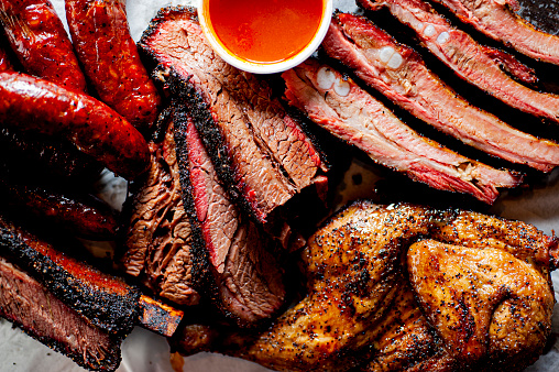 BBQ. Barbecue table spread. Beef brisket, chicken, pork ribs, beef ribs, Mac n cheese, cornbread, Brussels sprouts, coleslaw & beer. Classic traditional Texas meats & side dishes.