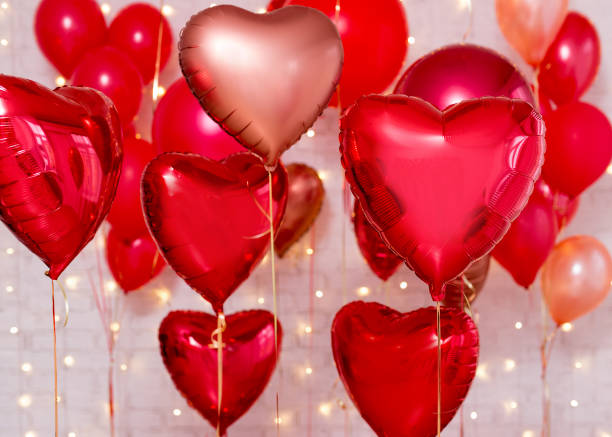 istock Valentine's day background - red foil heart shaped balloons over brick wall 1277777988