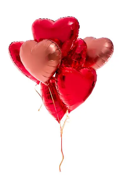 Photo of Valentine's day concept - bunch of red heart shaped balloons isolated on white