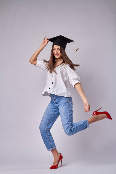 fille diplômée excitée saute. - women business graduation casual photos et images de collection