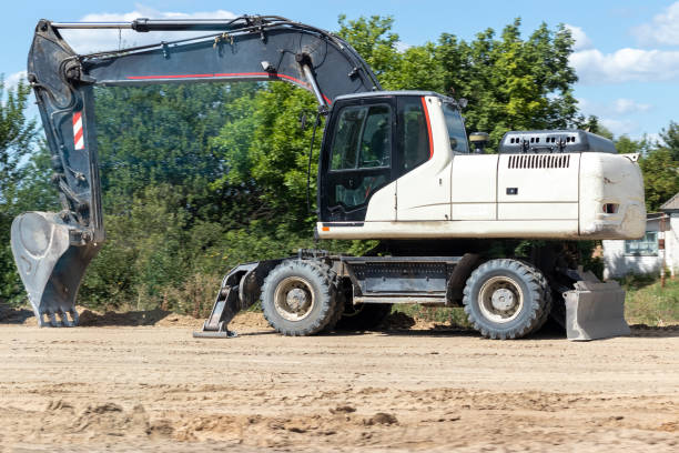 istock Modern white excavator standing on a ground. Digger with a bucket. Road work on an intercity highway 1277779059