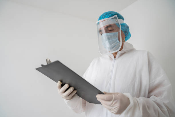 istock Doctor wearing PPE while working during the COVID-19 pandemic and reading chart on a clipboard 1277779119