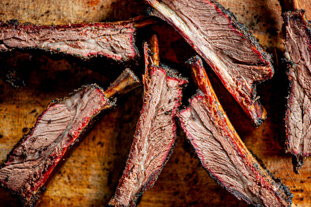 beef ribs. barbecue table spread. beef brisket, chicken, pork ribs, beef ribs, mac n cheese, cornbread, brussels sprouts, coleslaw & beer. classic traditional texas meats & side dishes. - sparerib imagens e fotografias de stock