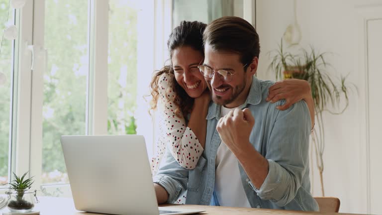 Couple use laptop read news scream with joy celebrating success