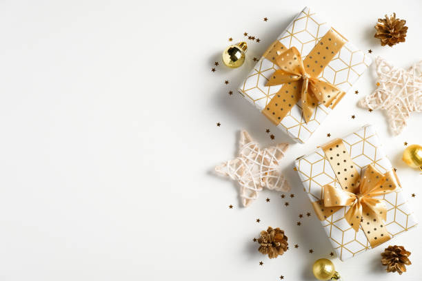 istock Christmas flat lay composition. Christmas golden decorations, gift boxes, stars, confetti on white background. Christmas, New Year, winter holiday celebration concept. Greeting card, postcard mockup 1277780853