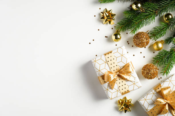 istock Christmas tree branches decorated golden balls, gift boxes, confetti on white background. Flat lay, top view. Xmas banner mockup with copy space 1277780857