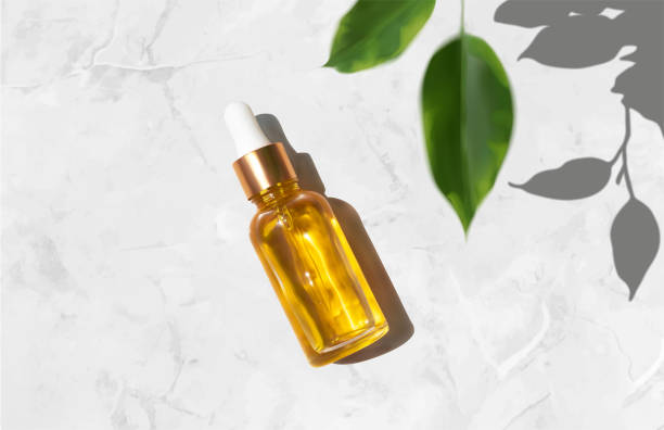 istock Oil serum glass bottle and defocused leaves with trendy hard shadow on luxury marble background realistic vector illustration, top view. Aromatherapy oil, concept of natural cosmetic 1277782802