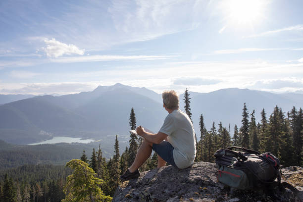 istock Male hiker relaxes on rock overlook, above valley 1277782844
