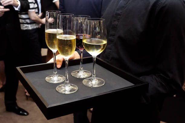 istock Waiter service white wine and red wine on black slate platter 1277782922