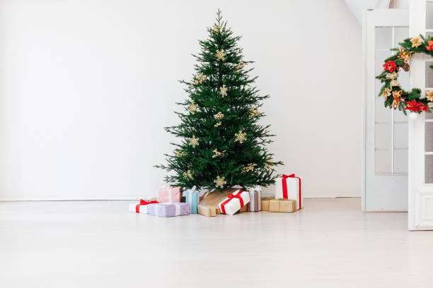 istock Stylish Christmas scandinavian minimalistic interior Christmas tree with light and bauble in sunny living room 1277783122