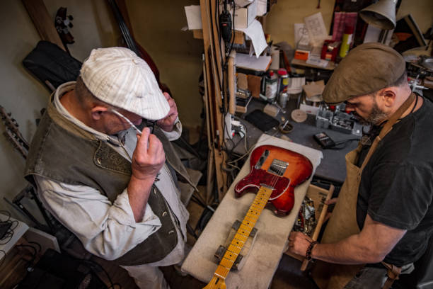 istock High Angle VIew on Carpenter and Customer Working on a Guitar 1277784148