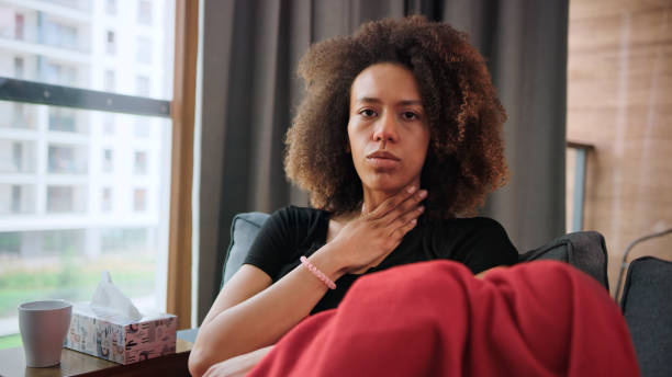 istock Sickly young woman staying on a couch. Having sore throat 1277786736