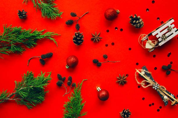 istock Winter composition with fir tree branches, decorative balls, cones and sequins on bright red background 1277787241
