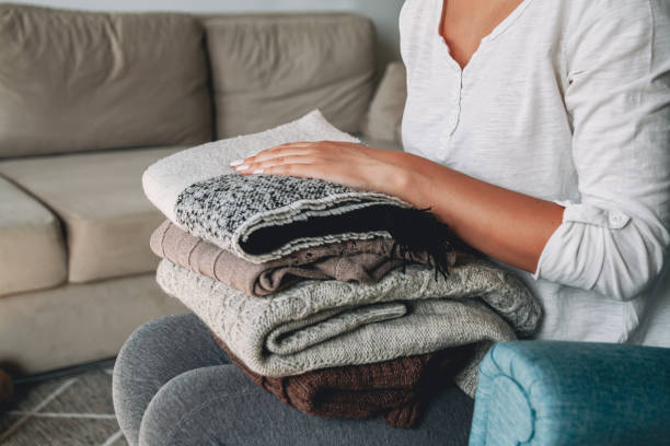 istock Female hands hold a stack of warm knitted sweaters 1277788046