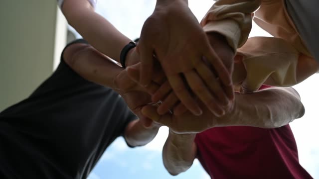 asian chinese Friends holding hand from angle below for hope and trust