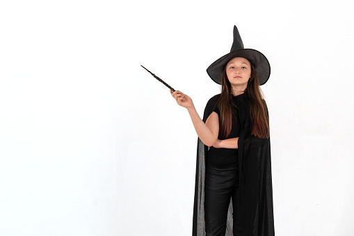 A girl dressed as Harry Potter with a magic wand in her hands