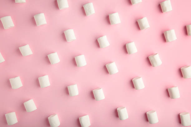 istock White marshmallows on a pink background. Top view 1277796171