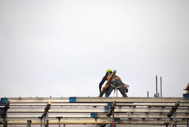 man at work construction site worker holding beam on roof structure building stock photo