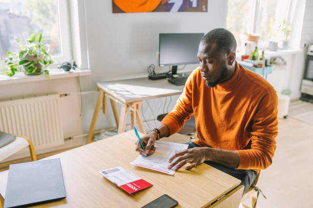 istock Man filling mail-in voting ballot at home 1277806159