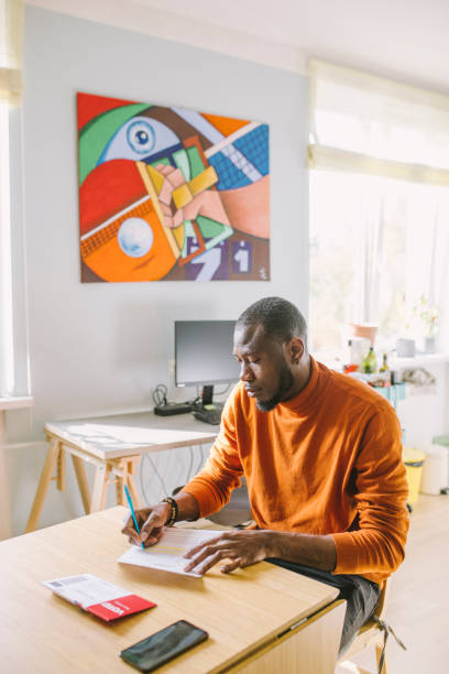 istock Man filling mail-in voting ballot at home 1277806169