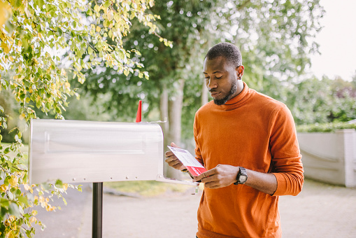 Portrait of African-American man receiving mail-in voting ballot.