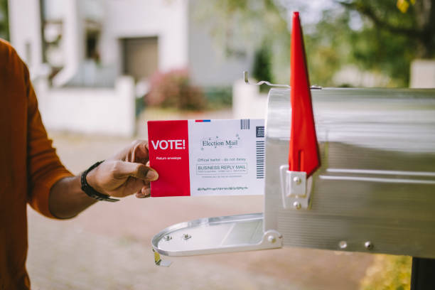 człowiek oddanie głosowania do skrzynki pocztowej. - mailbox zdjęcia i obrazy z banku zdjęć