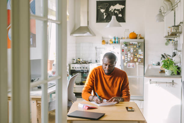 Man filling mail-in voting ballot at home